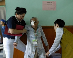 Volunteers accompany patient after the surgery. (Photo by Anand Yahya; date: 10/29/2010; location: Kota Singkawang, Indonesia)