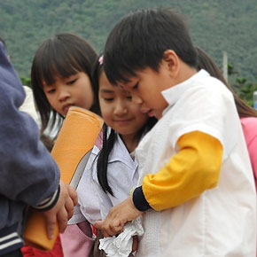 The student carefully takes out the money wrapped in a handkerchief. He wants to donate all he has to help the survivors of the Japan earthquake. (Photo by Ou Cheng-Hsiung; date: 03/30/2011; location: Jiamin Elementary School, Hualien County)