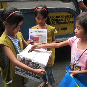 In the Philippines, Rachel and Lea, who were born Siamese twins and separated at the Tzu Chi Medical Center in Hualien in 2003, fundraise for the Japan Earthquake. Julie (right) donates the money she just earned. (Photo by Erika Vizcarra)
