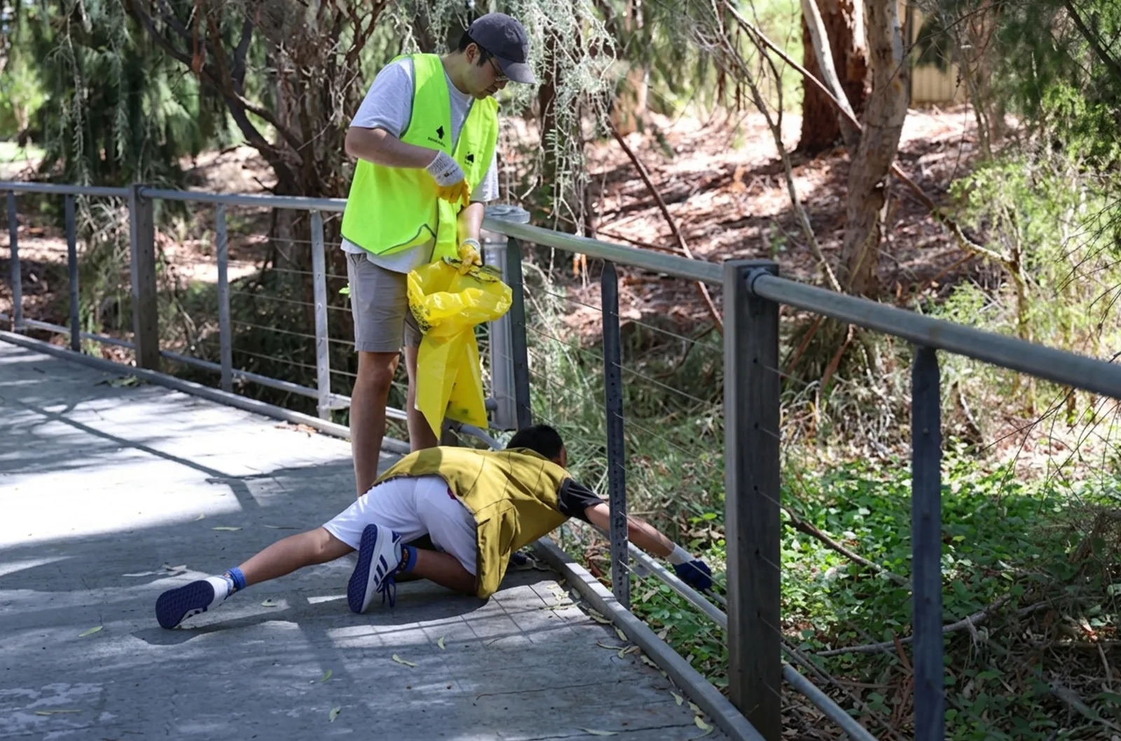 Perth - Clean Up Australia Day - A young volunteer refused to give up on litter thrown beyond the railing. Clean Up Australia Day - A young volunteer refused to give up on litter thrown beyond the railing.