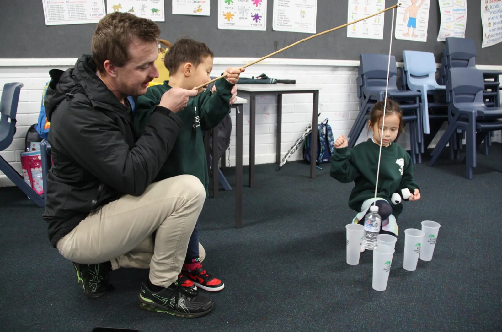 Tzu Chi Academy - A father patiently guided while the child concentrated on the challenge of suspending an empty cup with a water bottle